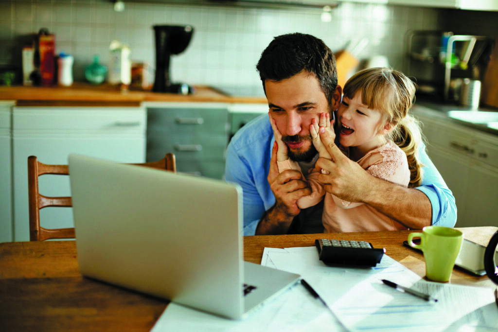 image of father studying at computer with daughter