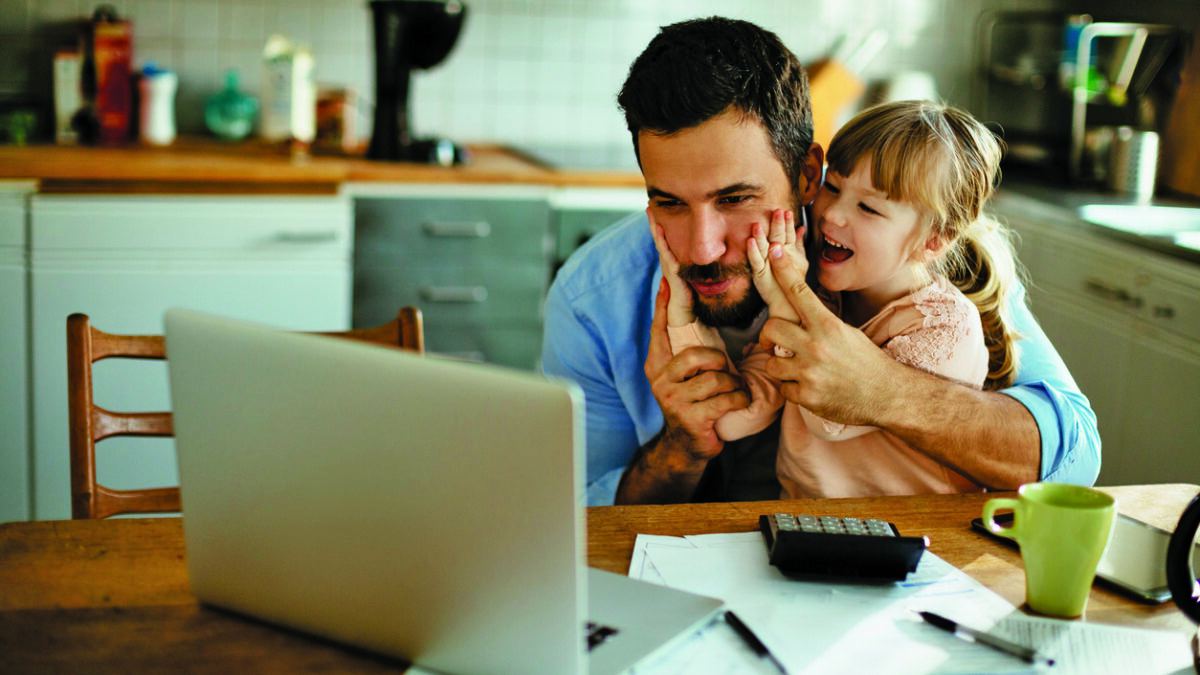 image of father studying at computer with daughter